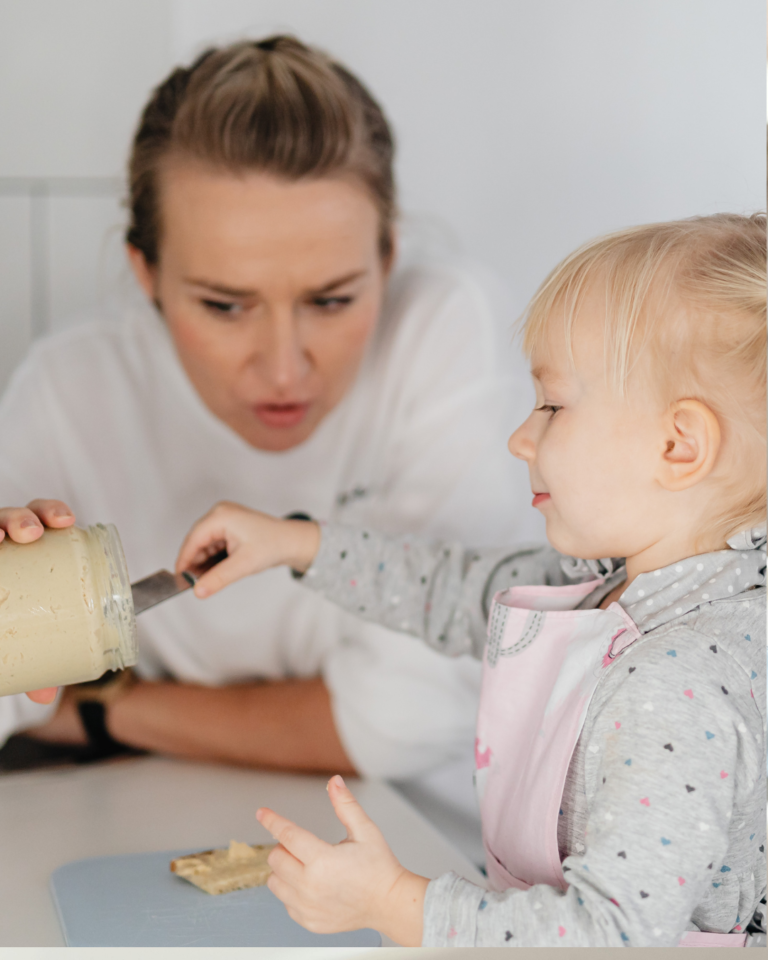 Mother feeding child food from a jar