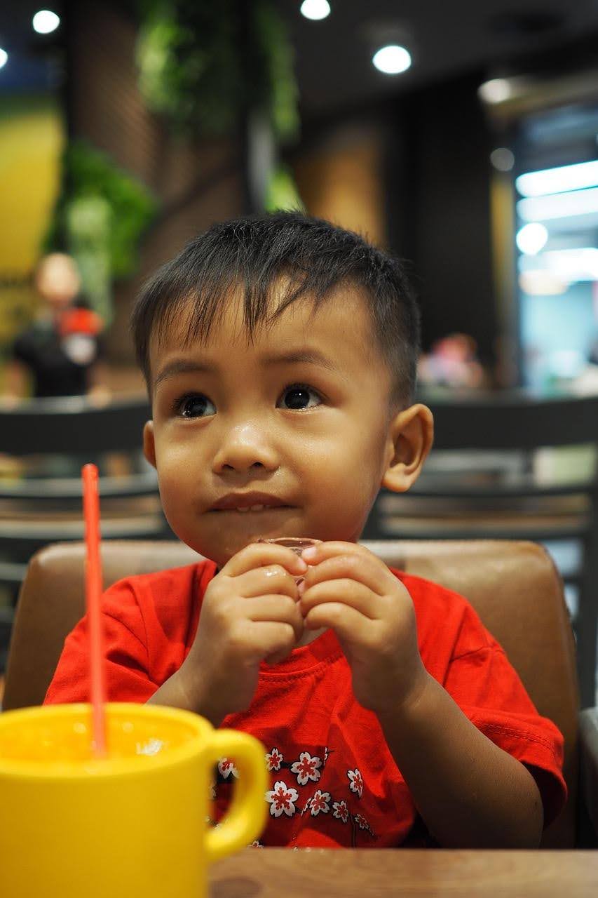 young toddler eating food at a table